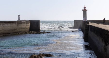 Faro en una playa de la ciudad de Oporto Portugal con olas dramáticas del océano atlántico
