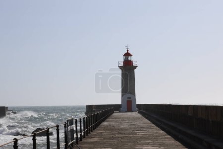 Lighthouse on a Porto city Portugal beach with dramatic waves of atlantic ocean