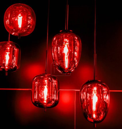 Luces rojas atractivas en la noche. Lampara roja en el interior de la casa. Encantadoras linternas rojas.