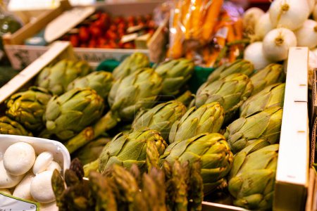 Foto de Beautiful and healthy green fresh artichoke vegetables lie in plastic boxes at the Spain street market. - Imagen libre de derechos