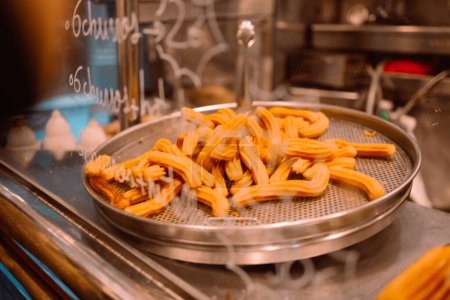 Photo for Delicious deep fried churros served on sale market. Traditional spanish and mexican street food, close-up - Royalty Free Image