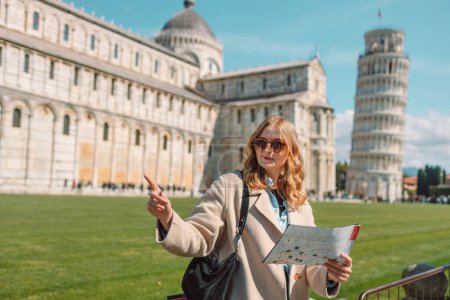 Foto de Joven viajera con mapa turístico cerca de la famosa torre inclinada en el casco antiguo de Pisa. Felices vacaciones en Italia. Foto de alta calidad - Imagen libre de derechos