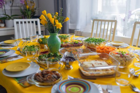 Foto de Tradicional desayuno de Pascua polaco en una mesa festiva con una decoración elegante brillante y platos clásicos en un mantel amarillo. Mesa festiva familiar - Imagen libre de derechos