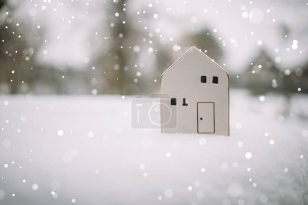 Merry Christmas and 2024 happy new year banner with small toy model house on a white snow background. Miniature white toy house model . High quality photo
