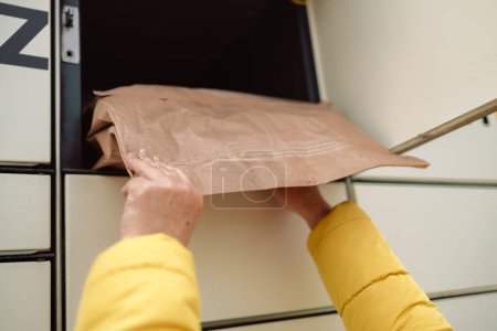 Photo for Woman putting box to automated parcel machine. - Royalty Free Image