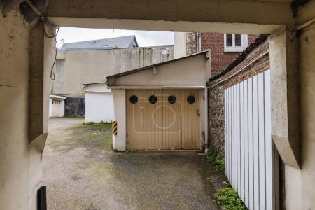 Photo for Picture of a courtyard with old garages surrounded by run down buildings - Royalty Free Image
