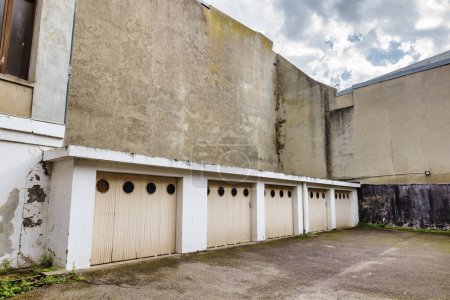 Photo for Courtyard with old garages surrounded by run down buildings - Royalty Free Image