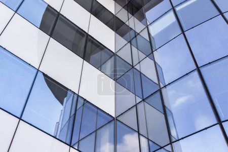 Foto de Fachada de cristal de un moderno edificio de oficinas con reflejos en las ventanas - Imagen libre de derechos