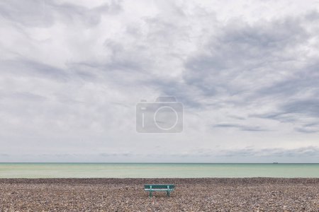 Téléchargez les photos : Banc sur la plage de galets du Treport, France, avec ciel couvert - en image libre de droit