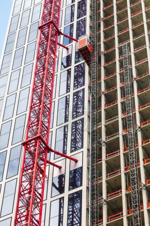 Téléchargez les photos : Photo d'un chantier avec une grue sur un nouveau bâtiment de grande hauteur - en image libre de droit