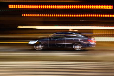 Foto de Abstracta imagen borrosa de un coche de conducción en una calle de la ciudad por la noche - Imagen libre de derechos