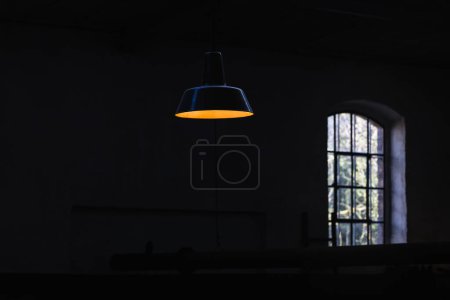 Foto de Imagen con una lámpara de techo brillante delante de una pared negra - Imagen libre de derechos