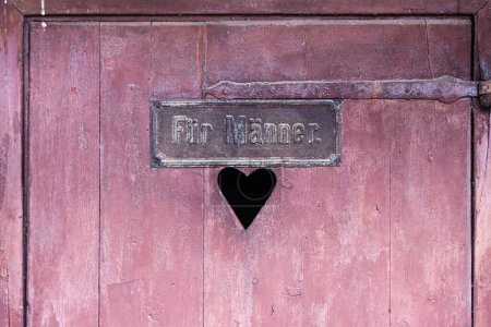 Photo for Picture of a wooden door of an antique toilet with a sign with the German words Fuer Maenner meaning for men - Royalty Free Image