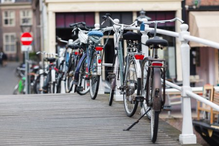 Photo for Row of bicycles parking at the railing of a canal bridge in Amsterdam, Netherlands - Royalty Free Image