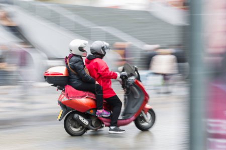Foto de Imagen en movimiento intencional desenfoque de una pareja en un scooter que conduce en la ciudad - Imagen libre de derechos