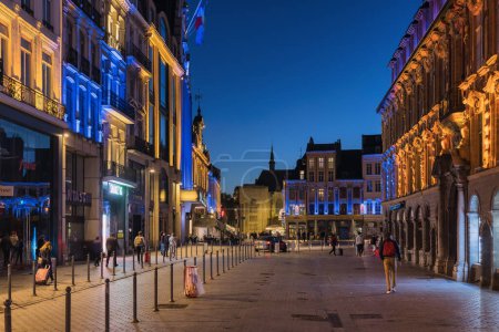 Téléchargez les photos : Lille, France - 02 octobre 2022 : Bâtiments illuminés à la Grand-Place la nuit, avec des personnes non identifiées.Lille est la capitale des Hauts-de-France - en image libre de droit