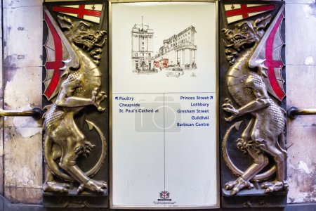 Téléchargez les photos : Londres, Royaume-Uni - 16 juin 2016 : Des sculptures de dragon portant les armoiries de la Ville de Londres encadrent un panneau indicateur souterrain. Les dragons servent à protéger la ville - en image libre de droit