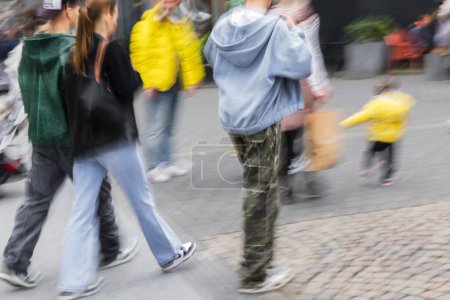 Foto de Imagen con el desenfoque del movimiento de una multitud de personas de compras caminando en una zona peatonal - Imagen libre de derechos