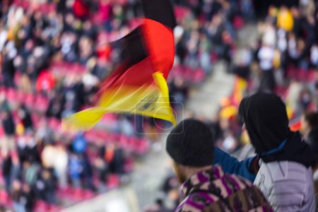 Foto de Imagen fuera de foco de las personas con bandera nacional alemana en un partido de fútbol en el estadio - Imagen libre de derechos