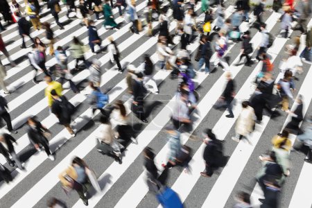 Photo for Picture with intentional motion blur of crowds of people who are crossing a city street at a zebra crossing in Tokyo, Japan - Royalty Free Image