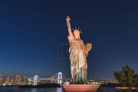 Photo for Statue of Liberty at the Odaiba Seaside Park with the Rainbow Bridge in the background, in Tokyo, Japan, at night - Royalty Free Image