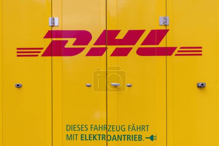 Téléchargez les photos : Munich, Allemagne - 05 avril 2023 : Logo de la société DHL sur une camionnette jaune avec moteur électrique. DHL est une entreprise allemande de logistique fondée aux États-Unis, qui livre plus de 1,8 milliard de colis par an - en image libre de droit