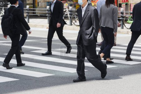 Photo for Picture of businessmen crossing a street in Tokyo, Japan - Royalty Free Image