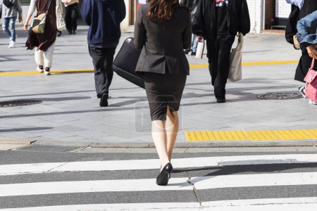 Téléchargez les photos : Photo d'une femme d'affaires traversant une rue animée de la ville - en image libre de droit