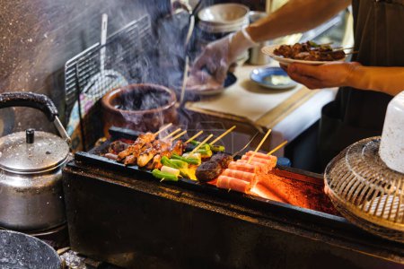Téléchargez les photos : Photo d'un chef méconnaissable préparant des plats dans une cuisine traditionnelle de rue à Tokyo, au Japon - en image libre de droit