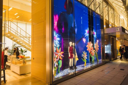 Photo for Osaka, Japan - April 13, 2023: store window of a Louis Vuitton store with unidentified people at night. Louis Vuitton is a French luxury fashion house and company founded in 1854 - Royalty Free Image