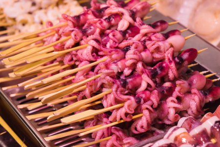 Téléchargez les photos : Exposition de brochettes de calmars crus au célèbre marché aux poissons Nishiki à Kyoto, au Japon - en image libre de droit
