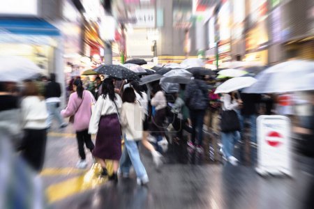 Téléchargez les photos : Foule de personnes avec des parasols en mouvement dans le quartier Shibuya à Tokyo, au Japon, alors qu'il pleut - en image libre de droit
