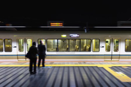 Téléchargez les photos : Image avec flou de mouvement intentionnel d'un train la nuit dans une gare au Japon - en image libre de droit