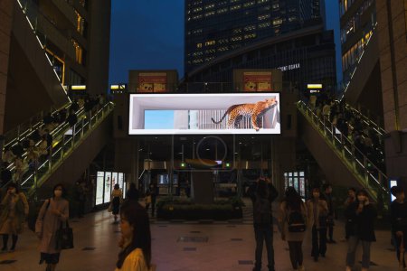 Téléchargez les photos : Osaka, Japon - 14 avril 2023 : Mur vidéo à Osaka Station avec représentation réaliste d'un peuple léopard non identifié. La gare d'Osaka est une gare ferroviaire importante dans le quartier d'Umeda - en image libre de droit