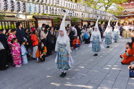 Téléchargez les photos : Tokyo, Japon - 09 avril 2023 : défilé dans un Matsuri au temple Senso-Ji à Asakusa, avec des personnes non identifiées. Matsuri sont des festivals japonais traditionnels généralement parrainés par un sanctuaire ou un temple local - en image libre de droit