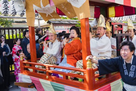 Téléchargez les photos : Tokyo, Japon - 09 avril 2023 : défilé dans un Matsuri au temple Senso-Ji à Asakusa, avec des personnes non identifiées. Matsuri sont des festivals japonais traditionnels généralement parrainés par un sanctuaire ou un temple local - en image libre de droit