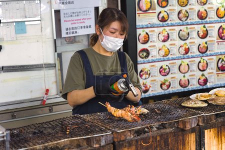Foto de Tokio, Japón - 11 de abril de 2023: escena nocturna en una cocina callejera en Tokio, Japón, con personas no identificadas. Tokio tiene una famosa industria alimentaria con muchas especialidades y más de 50.000 restaurantes - Imagen libre de derechos