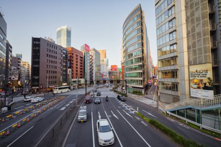 Téléchargez les photos : Tokyo, Japon - 11 avril 2023 : vue sur la rue avec la circulation et les gratte-ciel dans le quartier de Nishi-Shinjuku. Nishi-Shinjuku est un quartier d'affaires de Shinjuku, Tokyo. - en image libre de droit