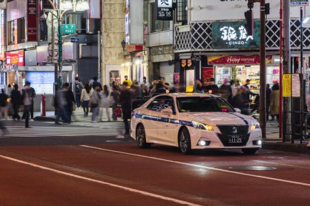 Foto de Tokio, Japón - 11 de abril de 2023: estacionamiento de taxis en una calle de la ciudad en el distrito de Shinjuku con personas no identificadas. El distrito de Shinjuku es un importante centro comercial y administrativo en Tokio. - Imagen libre de derechos