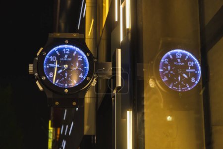 Foto de Osaka, Japón - 13 de abril de 2023: Vista nocturna de un reloj de gran tamaño como un signo de la compañía para los relojes Hublot. Hublot es un relojero de lujo suizo fundado en 1980 por el italiano Carlo Crocco - Imagen libre de derechos