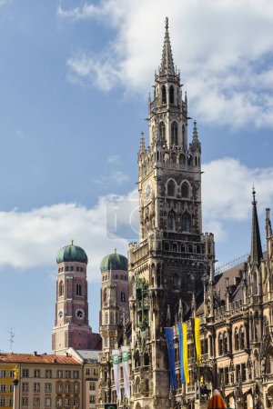 Téléchargez les photos : Munich, Allemagne - 05 avril 2023 : Tour de la nouvelle mairie avec la Frauenkirche en arrière-plan. Munich est la capitale et la ville la plus peuplée de l "État libre de Bavière - en image libre de droit
