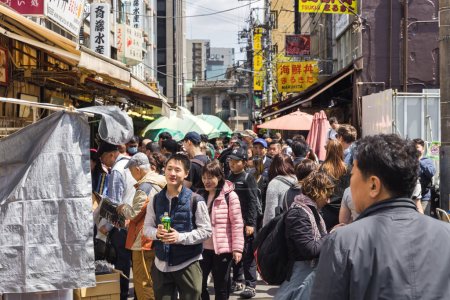 Téléchargez les photos : Tokyo, Japon - 12 avril 2023 : Scène de rue sur le marché aux poissons de Tsukiji avec des personnes non identifiées. C'est une attraction touristique majeure. Avant 2018, c'était le plus grand marché de gros de poisson au monde - en image libre de droit