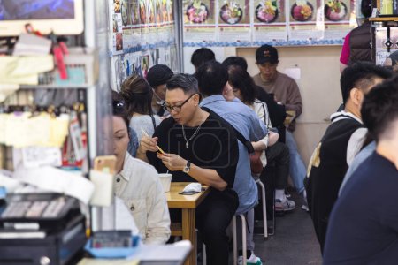 Téléchargez les photos : Tokyo, Japon - 12 avril 2023 : restaurant typique au marché aux poissons de Tsukiji avec des personnes non identifiées. C'est une attraction touristique majeure. Avant 2018, c'était le plus grand marché de gros de poisson au monde - en image libre de droit