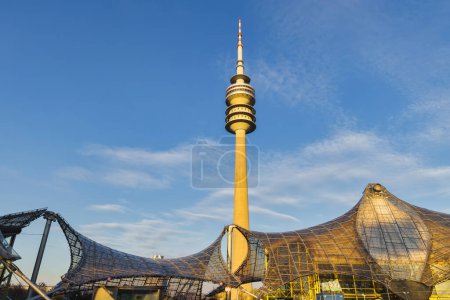 Foto de Múnich, Alemania - 05 de abril de 2023: Olympiahalle con Torre Olímpica en el Parque Olímpico de Múnich. Es una arena polivalente. El Parque Olímpico fue construido para los Juegos Olímpicos de 1972 - Imagen libre de derechos