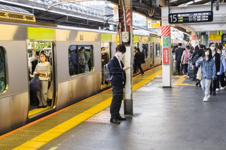 Foto de Tokio, Japón - 10 de abril de 2023: escena en una estación de tren en Tokio, con personas no identificadas. Tokio es el mayor centro nacional e internacional de transporte ferroviario y terrestre de Japón - Imagen libre de derechos