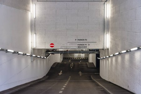 Téléchargez les photos : Photo de l'entrée ou la sortie d'un garage de stationnement, l'écriture sur le mur signifie Parking P2 et Parking P1 visiteurs en anglais - en image libre de droit