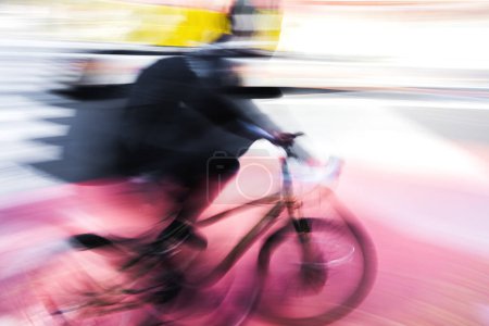 Foto de Foto abstracta con desenfoque de movimiento de un ciclista en el tráfico de la ciudad - Imagen libre de derechos
