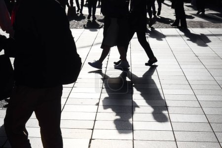 Foto de Imagen de siluetas retroiluminadas de peatones caminando en una zona peatonal - Imagen libre de derechos