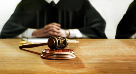 Foto de El martillo del juez simboliza el juicio sobre la mesa de madera judicial en la sala del tribunal frente al juez en el trono del juez - Imagen libre de derechos