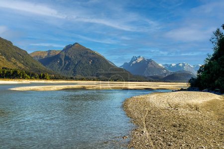 The meandering Dart river flowing through the alpine valley towards the snow capped Southern alps mountain range on the outskirts of Glenorchy New Zealand